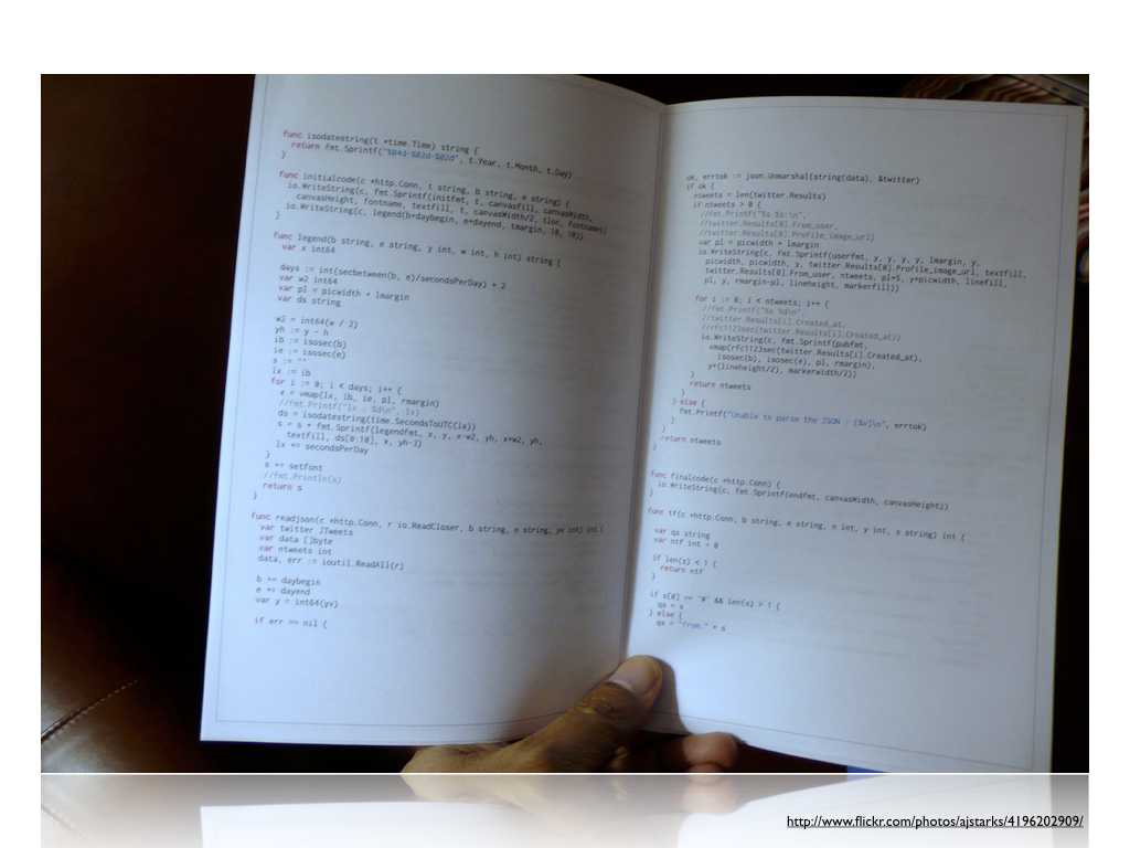 A photo of a hand holding open a book, the pages show (Go) code; text: https://www.flickr.com/photos/ajstarks/4196202909/